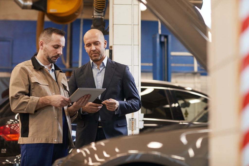 Businessman Checking in Car for Inspection