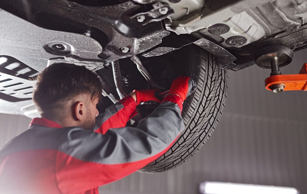 Mechanic fixing car suspension in garage